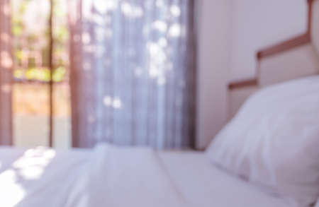 Abstract blurred white bedroom with open curtain window for backgroundの写真素材