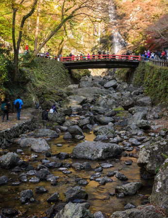 Minoo waterfall with red bridge in autumn at Minoo or Minoh national park in Osaka, Japan . One of Japan's oldest national parks.のeditorial素材