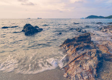Beach with rocks at sunrise. Vintage filtered effect image.の写真素材