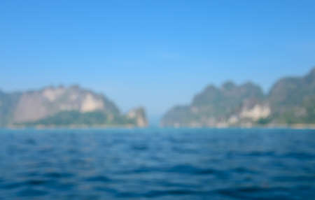 Blurred abstract image of deep blue sea and tropical island for travel nature background