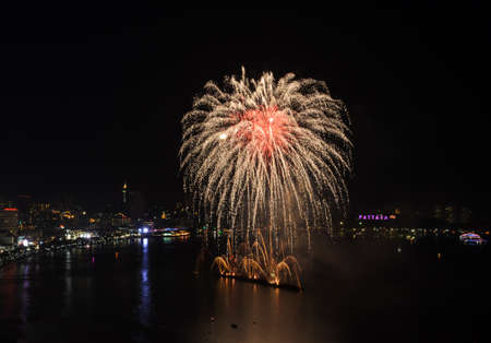 Big yellow firework on the sky at Pattaya coast with cityscape background, Thailand