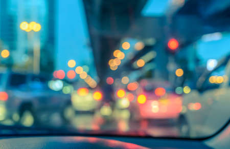 Blurred abstract background of car seen through windscreen with bokeh lights at twilight. Vintage color effect imageの写真素材