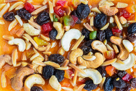 Fruitcake topped with mix fruits and Cashew nuts texture background