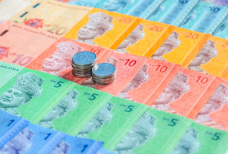 Malaysia currency of Malaysian ringgit banknotes and coins background. Sen coins of fIve and ten on...