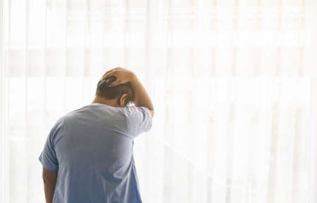 Back view of Asian male patient pain and stress on her sickness in hospital room. Healthcare concept.の写真素材