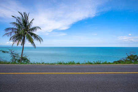 Beautiful coastal road with coconut palm tree and tropical seascape scenery backgroundの写真素材