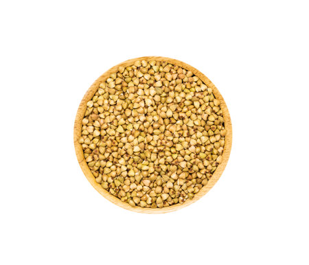 Buckwheat grainns in brown wooden bowl isolated on white background, top view. Healthy organic super food conceptの写真素材
