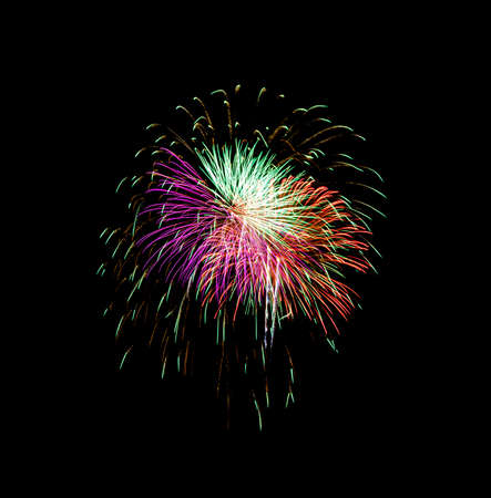 Beautiful colorful fireworks exploding in the night sky, isolated on black background. New year and anniversary concept.の写真素材