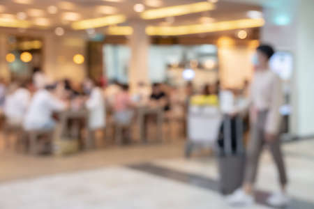 Blur passenger walking with luggage in front of cafe or restaurant in airport terminal for backgroundの写真素材