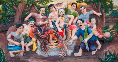 Bangkok, Thailand -  April 15, 2021 : Stone carving of traditional Thai rural cockfighting on temple wall in Bangkok, Thailandのeditorial素材