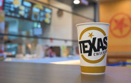 Bangkok, Thailand - December 17, 2020: Texas soft drink paper cup on wooden table. Church's Texas Chicken is a U.S. based chain of fast food restaurant specializing in fried chicken.のeditorial素材