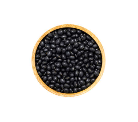 Black soybeans in brown wooden bowl isolated on white background, top view. Healthy organic super food conceptの写真素材