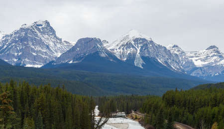 Panorama view Nicholas Morant's Curve on Canadian Pacific Railway with Three Sisters Rocky Mountains in early winter at Morant's Curve in Banff National Park, Alberta, Canadaの写真素材
