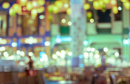 Blurred of coffee shop and restaurant with bokeh coloful night lights background. Retro filtered effect imageの写真素材