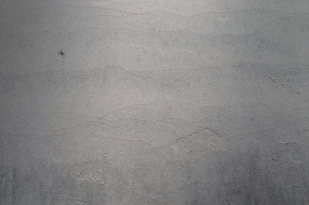 Grey abstract background of wet sand texture occured by sea waves on beachの写真素材
