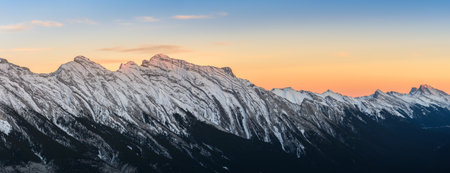 Panoramic sunset skyline of snow capped Canadian Rocky mountains at Banff National Park in Alberta, Canada. View from Banff Gondola Sulphur Moutain.の写真素材
