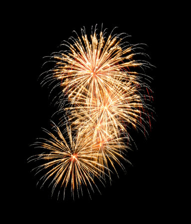Festive yellow fireworks display isolated on black background for celebration and anniversaryの写真素材