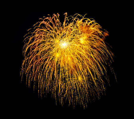 Festive golden fireworks display isolated on black background for celebration and anniversaryの写真素材
