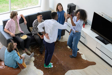 Diversity group of friends having party together at home. Happiness young people having fun dancing, playing guitar and singing in the living room. Top view image. Youth lifestyle conceptの写真素材