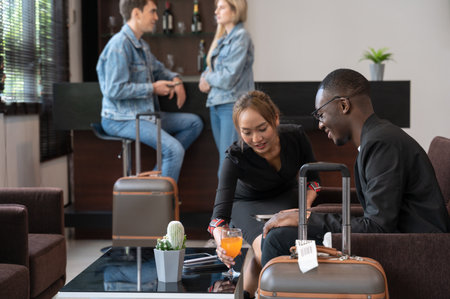 Airport lounge waitress serving orange juice to African businessman passenger. Black male waiting for his flight.の写真素材