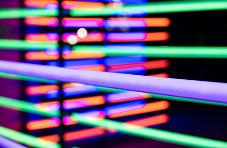 Abstract blurred image of vibrant neon lights in green, blue, purple and red color in horizontal linesの写真素材