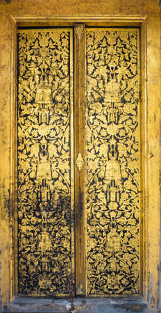 Temple Door Art at Wat Rakhangkhositraram Bangkok Thailand. This use the gilding gold leave on the black lacquer method.の写真素材