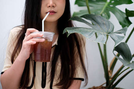 A beautiful girl drinking coffee with green leaf plant.の写真素材