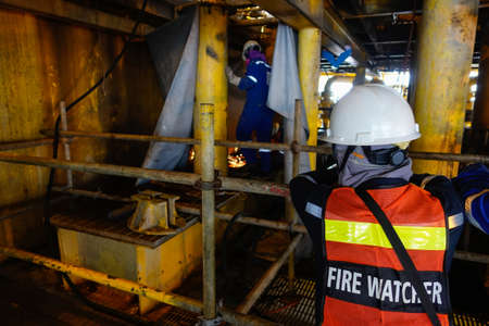 Fire watcher watch welder weld gas pipe casing for stop work in case of gas explosive, working in...