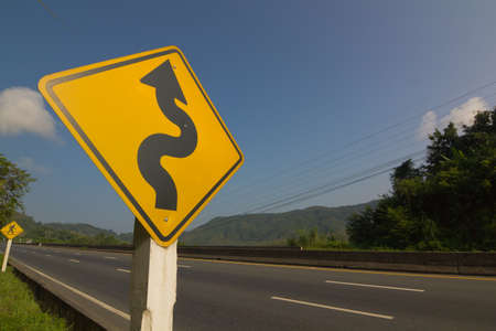 Winding road sign on blue skyの写真素材