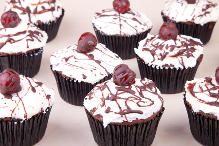 cherry chocolate cupcakes with white icingの写真素材
