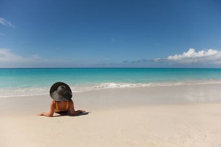 girl with hat relaxing in the tropical beachの写真素材