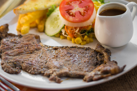 Beef steak with black pepper sauce , salad and French fries on sack backgroundの写真素材