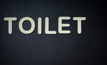 Toilet sign on blackwall background.の写真素材
