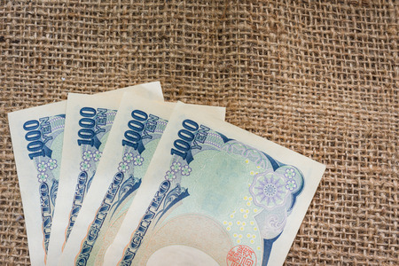 Yen money and yen coin with passport on sack background for travel or business concept.の写真素材