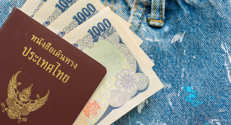 Thai passport in blue jeans pockets , traveler concept.の写真素材