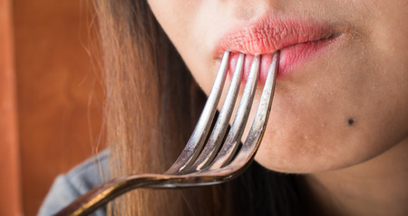 Close up women mouth eating with Spoon in  restaurant.の写真素材
