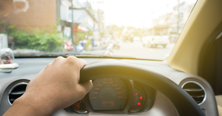 Driver eye view with hand on wheel in vintage style.