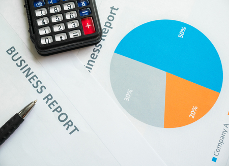 business report or Financial paper with pen and calculator in business concept