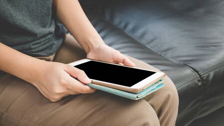 Women sit at the sofa using a tablet to communicate a social , online transactions or business contactの写真素材