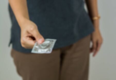Blur background of woman give condom in safe sex conceptの写真素材