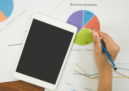 Working woman holding pen and teblet on bussiness reportの写真素材