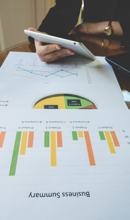 Working woman use tablet for work with Business summary or Business plan report with Charts and graphs in Business concept, vintage style.の写真素材