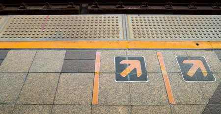 Arrow sign on Railway platform at train stationの写真素材
