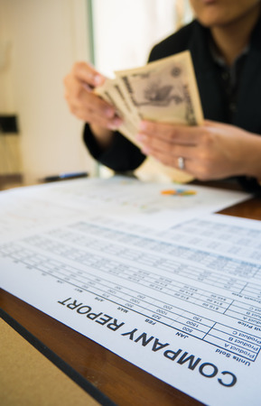 Japan money in hand with Statement paper in financial conceptの写真素材