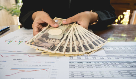 Japan money in hand with Statement paper in financial conceptの写真素材