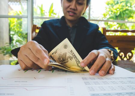 Woman is counting money with statement paper financial conceptの写真素材