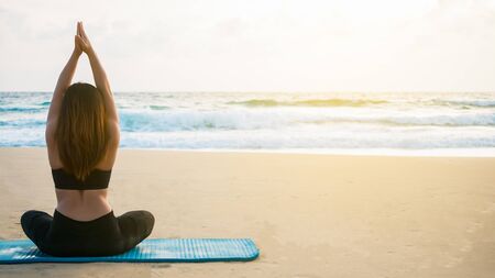 Young woman practices the yoga on the beach.の写真素材