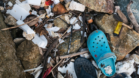 The problem of trash on the beach caused by man-made pollution and environmental in concept.の写真素材
