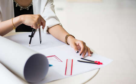 The female architects are using dividers in the design on the blueprints