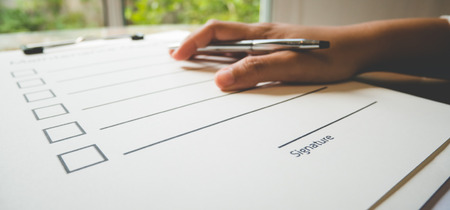 Close- up hand with pen on maintenance check paper and the format for filling in information in business concept,vintage style and soft toneの写真素材